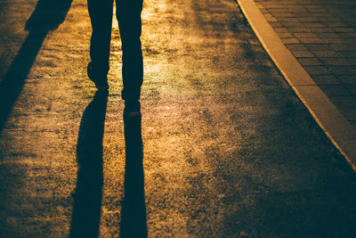 Low section of man walking on road at night