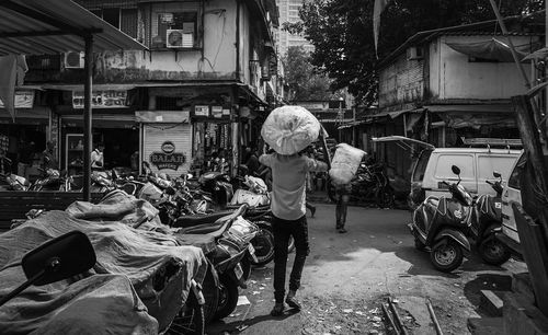Man standing on street amidst buildings in city