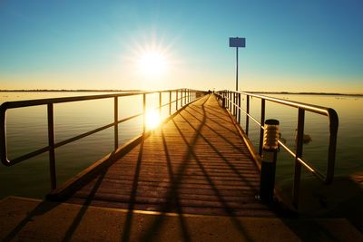 Morning in harbor. tourists walk on pier construction above sea. sunny blue sky, smooth water level