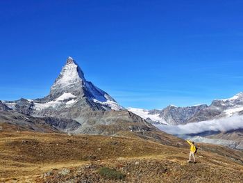 Scenic view of snowcapped mountains against blue sky