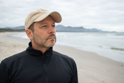 Portrait of young man standing at beach