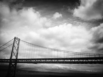 Low angle view of bridge against cloudy sky