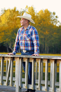 Man wearing hat while standing on pier