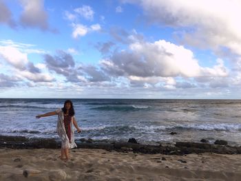 Smiling woman on beach against sky