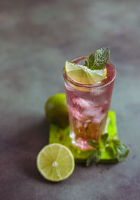 A fresh pink cocktail or mocktail drink with lime, pink grapefruit juice and mint. paloma.