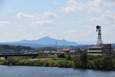 Scenic view of river by mountains against sky