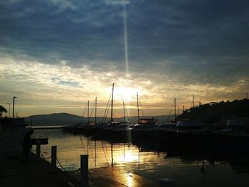 Boats in harbor at sunset