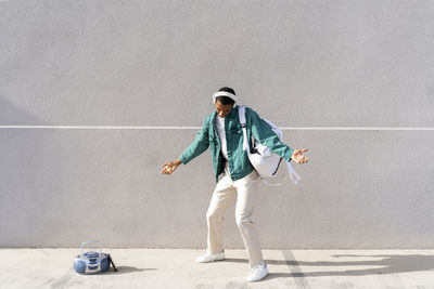 Full length of man standing against wall