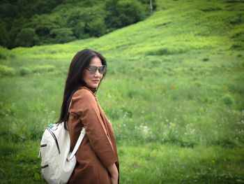 Portrait of young woman standing on field