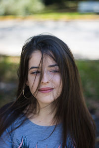 Close-up of young woman with tousled hair glancing sideways