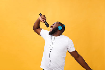 Young man singing against colored background