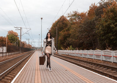 Full length portrait of woman on railroad tracks
