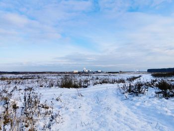 Scenic view of snow covered field against sky