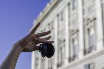 Close-up of hands holding metal equipment in city