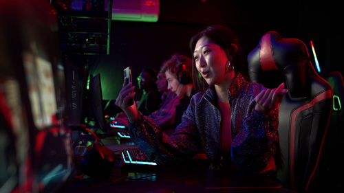 Side view of woman using mobile phone at internet cafe