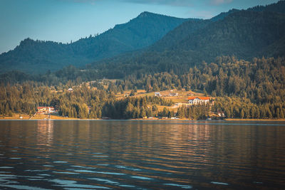 Scenic view of lake by mountains against sky