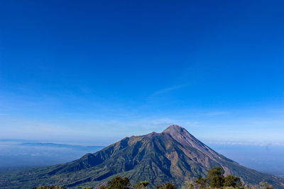 Scenic view of mountain against blue sky