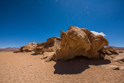 Rock formations in desert against blue sky