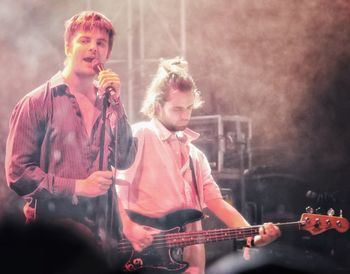 People playing guitar at music concert