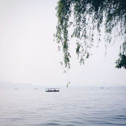 Boat sailing on sea against clear sky