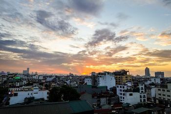 HIGH ANGLE SHOT OF TOWNSCAPE AGAINST SKY DURING SUNSET