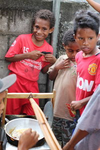 Portrait of friends standing against the wall