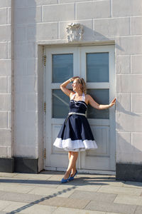 Rear view of woman standing against wall