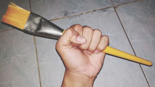 Cropped hand holding paintbrush