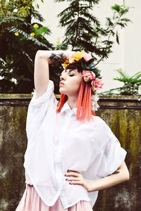 Portrait of woman standing against trees