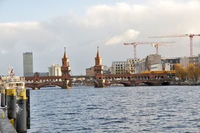 View of bridge over river against sky in city