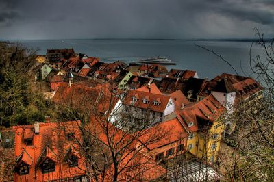 Houses by sea against sky