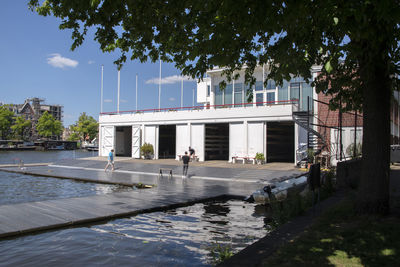 Building by swimming pool in city against sky