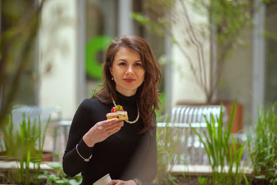 Portrait of young woman holding plant