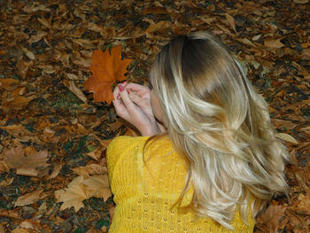 High angle view of woman with autumn leaves