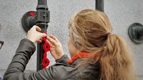 Rear view of woman using mobile phone in city