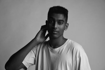 Portrait of young man standing against backdrop