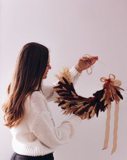 Woman holding flowers against white background