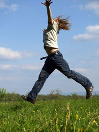 Woman jumping on grassy field