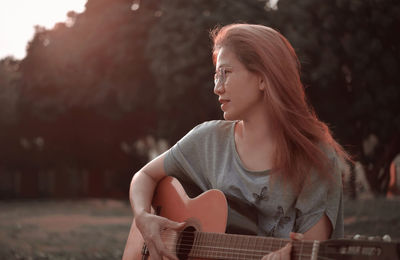 Woman playing guitar in the park