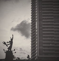 Low angle view of statue against building in city