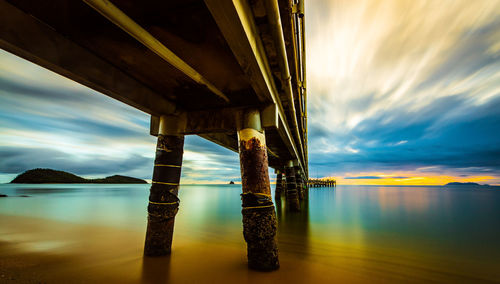 Bridge over river against sky during sunset