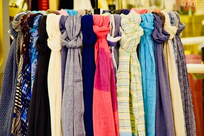 Multi colored scarves hanging on rack in store