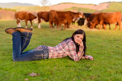 Side view of woman laying on grassy  field