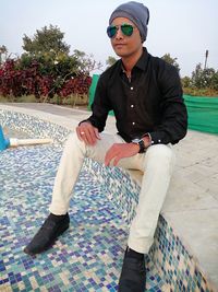 Young man wearing sunglasses sitting outdoors