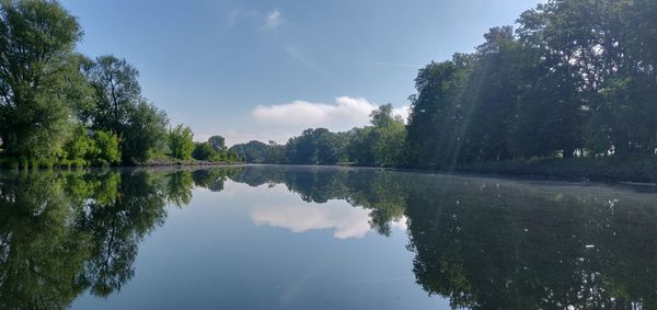 Scenic view of lake by trees against sky