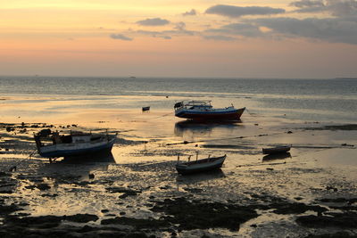 View of boats in sea at sunset