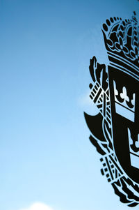 Low angle view of illuminated lamp against blue sky