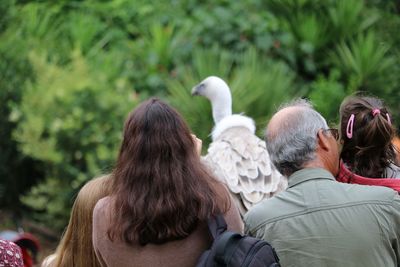 Rear view of people against bird at zoo