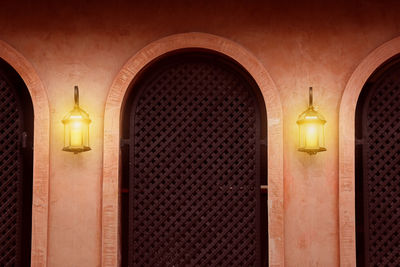 Illuminated street light on wall of building