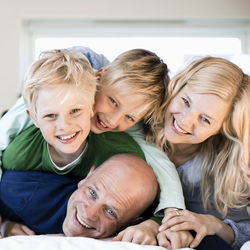 Portrait of happy family enjoying in bed